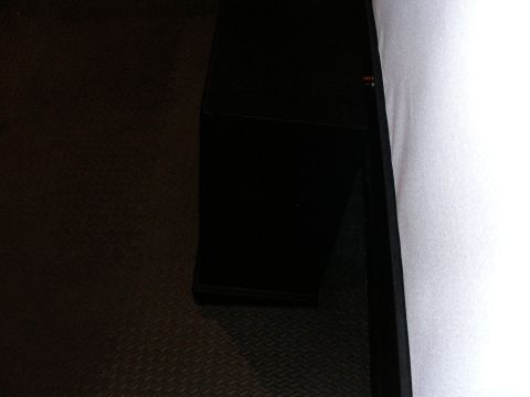 1987 Ford Bronco - A black box sits on a textured floor beside a white wall.
