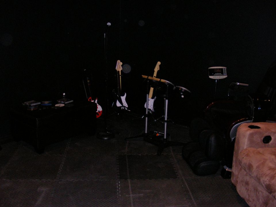 Guitars on stands and a chair in a dark room