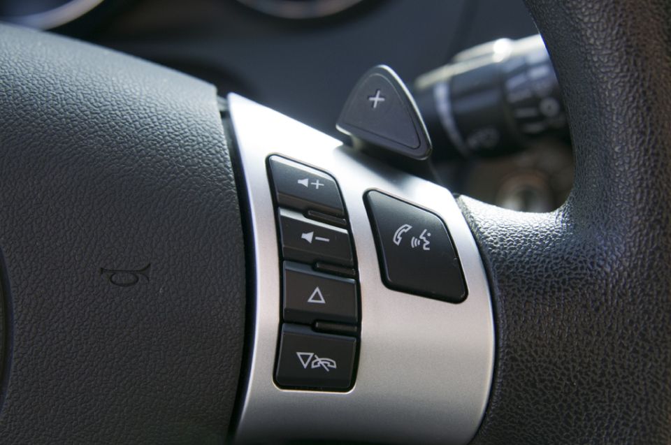 Close-up of steering wheel buttons, including volume, track change, and phone controls