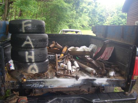 1992 Ford F-150 - The rear of a 1992 Ford F-150 is loaded with tires and various automotive parts.