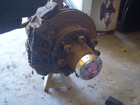 1992 Ford F-150 - Close-up of a rusty truck wheel hub and brake assembly, resting on jack stands.