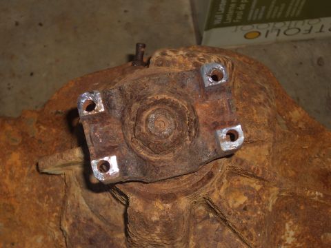 1992 Ford F-150 - Close-up of a heavily rusted differential housing with a four-bolt flange. The surface shows significant wear and corrosion.