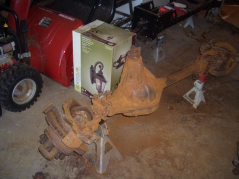 1992 Ford F-150 - A heavily rusted rear axle assembly is shown supported by jack stands in a garage setting.
