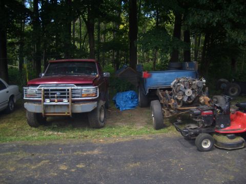 1992 Ford F-150 - 1992 Ford F-150 parked next to a disassembled truck chassis and a lawnmower.