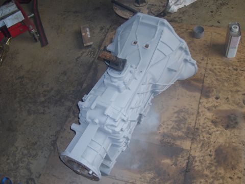 1992 Ford F-150 - Transmission assembly painted gray, resting on a wooden surface in a garage.