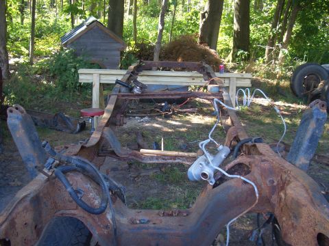 1992 Ford F-150 - A heavily rusted truck frame sits outdoors, awaiting restoration or parts.