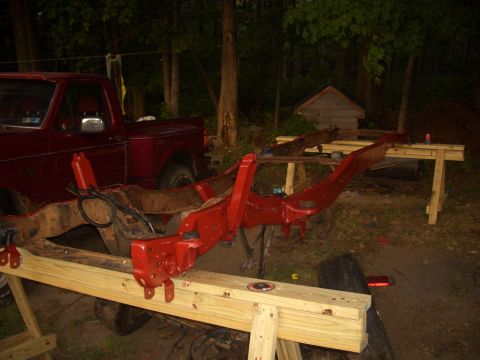 1992 Ford F-150 - The frame of a red 1992 Ford F-150 pickup truck is shown on sawhorses, likely undergoing restoration or repair.