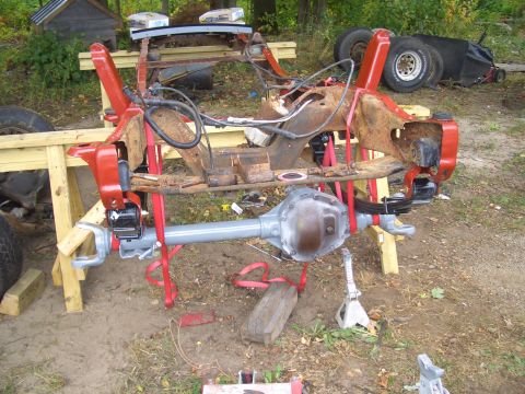 1992 Ford F-150 - Disassembled truck frame and suspension components are supported by sawhorses outdoors.