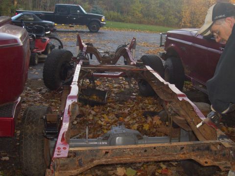 1992 Ford F-150 - A disassembled truck chassis sits on the ground, surrounded by fallen leaves and other vehicles.