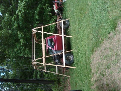 1992 Ford F-150 - Pickup truck cab and chassis being worked on, surrounded by a wooden frame structure.