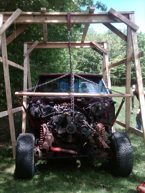 1992 Ford F-150 - Engine removal in progress for a maroon truck, supported by a custom wooden structure.