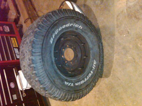 1992 Ford F-150 - BFGoodrich All-Terrain T/A tire on a black rim, with a red toolbox in the background.