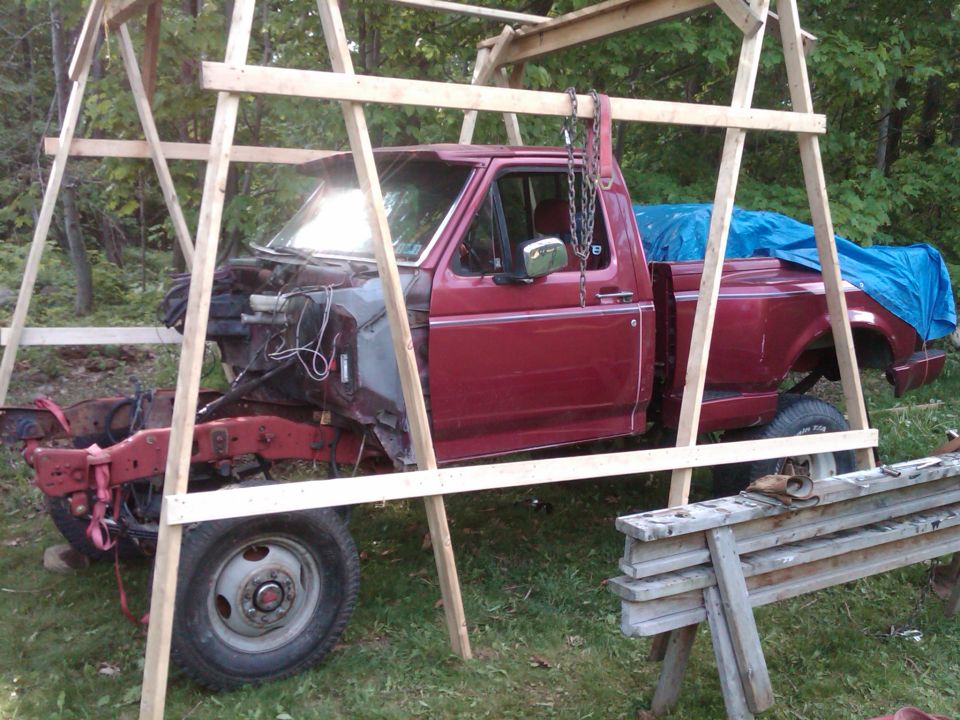 Side view of a red 1992 Ford F-150 pickup truck in a wooden frame