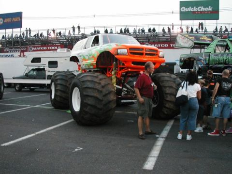1994 Ford Bronco - A custom-built monster truck with oversized tires and bright orange accents sits on display.