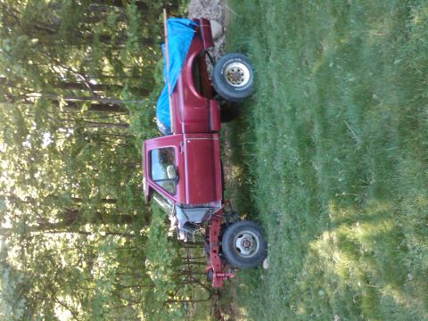 1992 Ford F-150 - This 1992 Ford F-150 pickup truck is missing its front end and bed, parked on a grassy area.