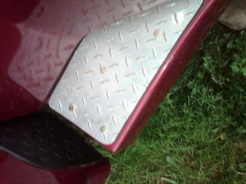 1992 Ford F-150 - Close-up of a diamond plate step pad attached to the fender of a red vehicle.