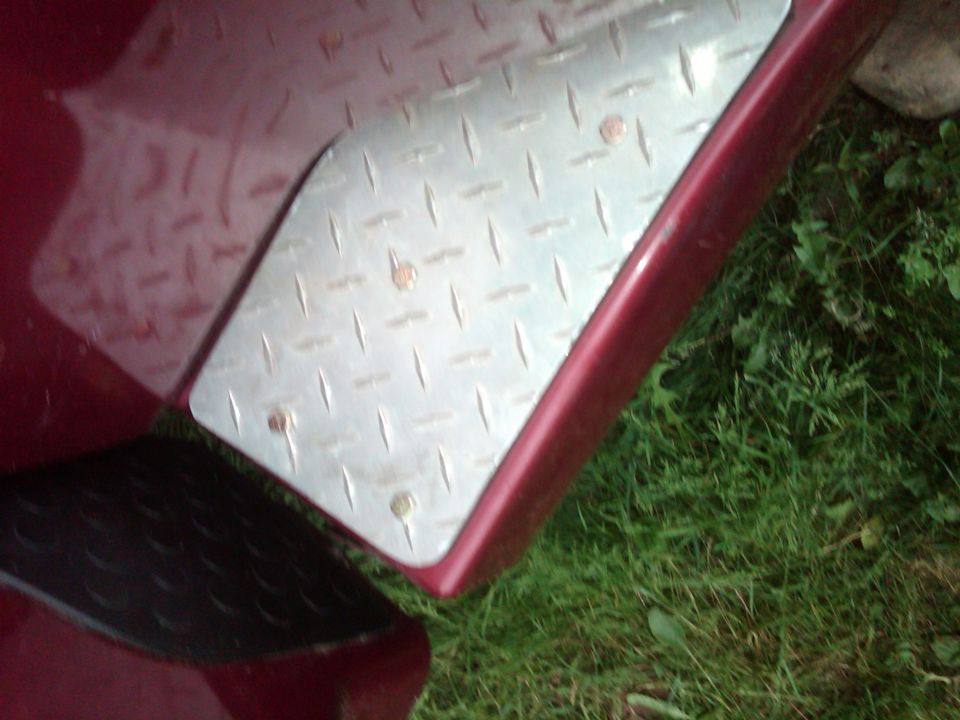 Diamond plate step pad on a red vehicle's fender