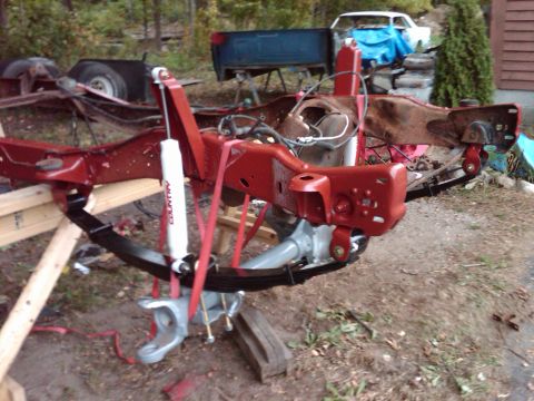 1992 Ford F-150 - Truck chassis and suspension components are laid out for work, with other vehicle parts visible in the background.