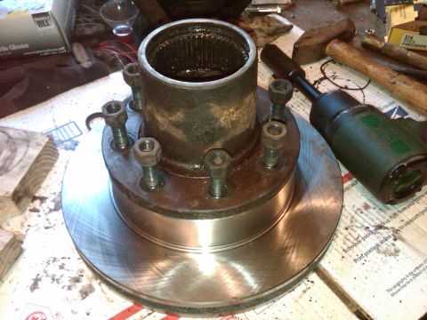 1992 Ford F-150 - A disassembled wheel hub and brake rotor assembly sits on a surface with various tools nearby.