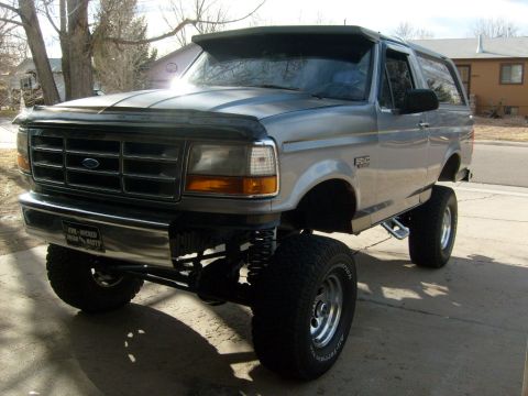 1986 Ford Bronco - This lifted Ford Bronco has a prominent aftermarket visor and large off-road tires.