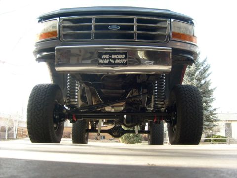 1986 Ford Bronco - Front view of a lifted Ford truck with a custom bumper displaying a humorous message.