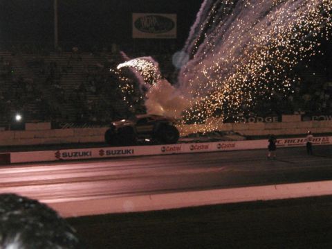 1994 Ford Bronco - A monster truck is on a drag strip with fireworks and smoke effects.