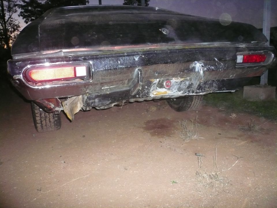 rear bumper and taillights of a dark-colored car with significant damage