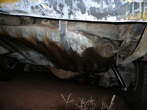 1975 Ford Ranchero - The underside of a vehicle is visible, focusing on the fuel tank and surrounding structural elements.