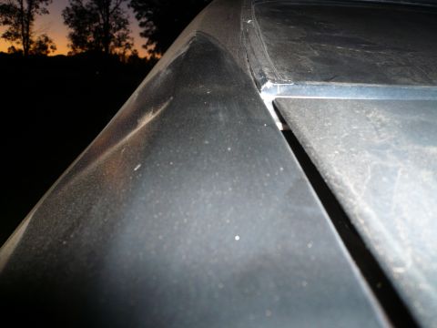 1975 Ford Ranchero - Close-up of a dusty car's roofline against a sunset sky, with visible panel gaps.