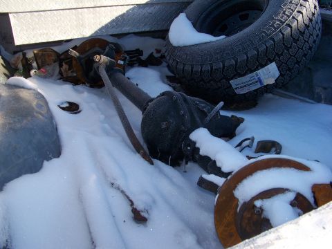 1987 Ford Ranger - A rear axle assembly and spare tire are seen in the snow, likely in a truck bed.