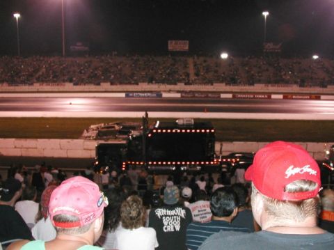 1994 Ford Bronco - A crowd watches a decorated semi-truck at a nighttime drag racing event.