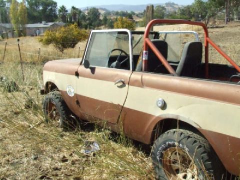 1961 International Scout 800 - This two-tone International Scout, likely a 1961 model, sits in a field with a red roll cage visible.