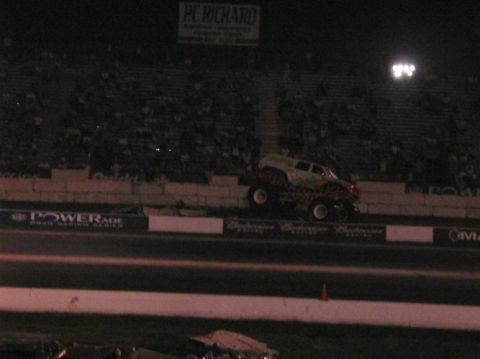 1994 Ford Bronco - A monster truck performs at a nighttime event with spectators in the background.