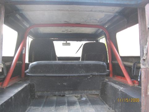 1961 International Scout 800 - The interior of a 1961 International Scout 800 features a roll cage and black seats.