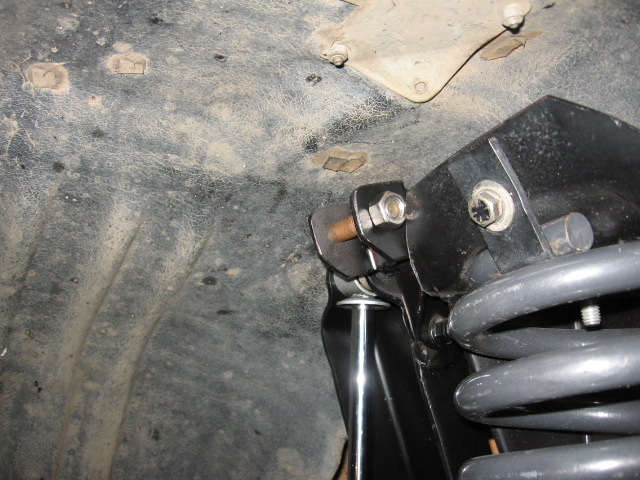Suspension mount with bolts, chrome shock shaft, and gray coil spring