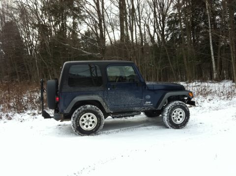 1972 Ford Ranchero - Jeep Wrangler parked in a snowy wooded area during winter.