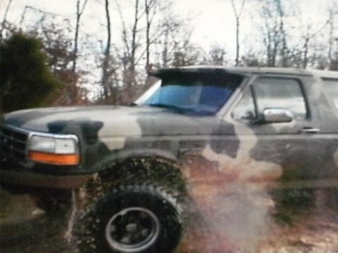 1995 Ford Bronco - This 1995 Ford Bronco is shown in a three-quarter front view as it drives through water, kicking up spray.