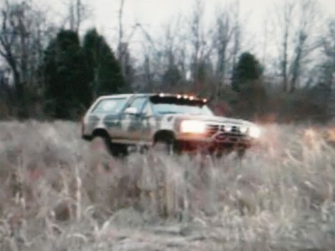 1995 Ford Bronco - This Ford Bronco is navigating through a field of dry grass and brush.