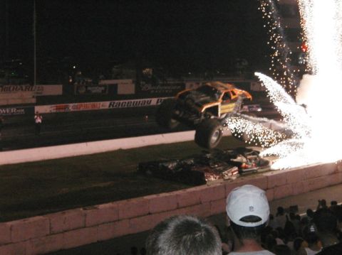 1994 Ford Bronco - A monster truck performs a jump amidst a shower of fireworks at a nighttime event.