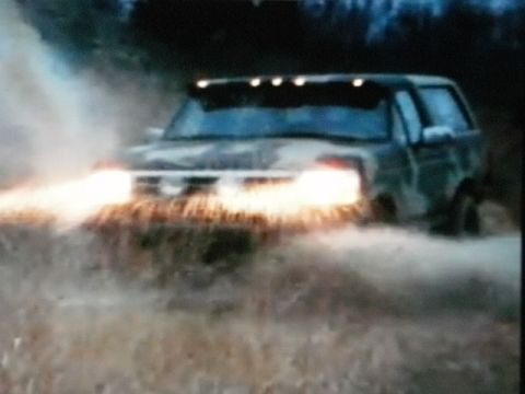 1995 Ford Bronco - This 1995 Ford Bronco navigates through murky water, its headlights cutting through the spray.