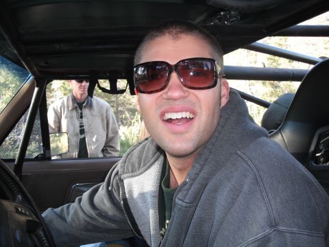 1991 Ford Bronco - Two men inside a vehicle, one in the driver's seat wearing sunglasses.