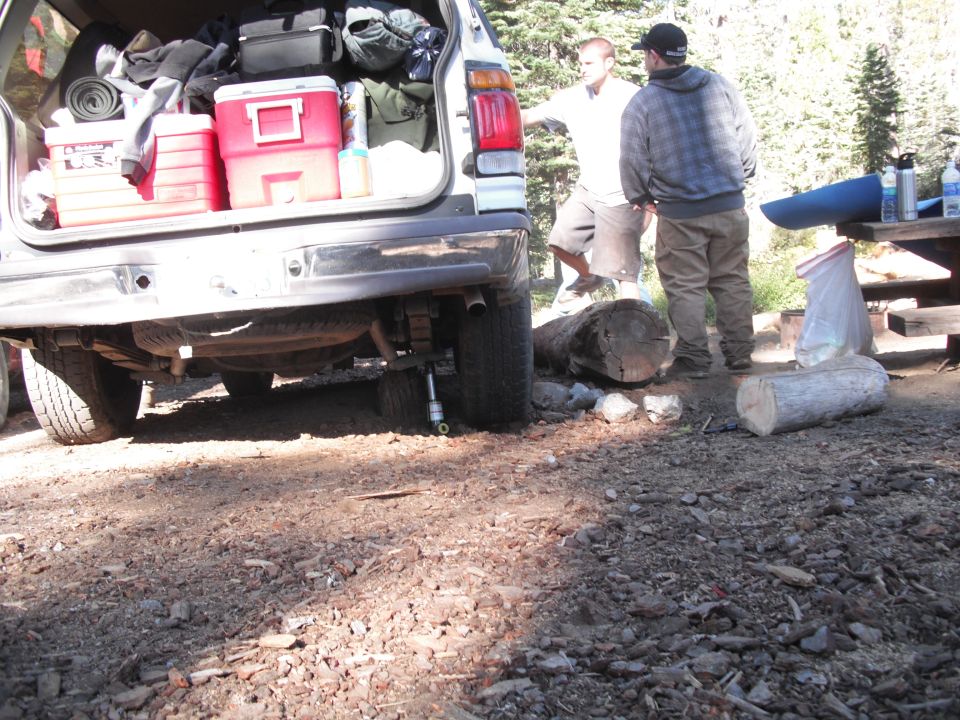 Rear view of a silver Ford Bronco with its tailgate open, packed with camping gear