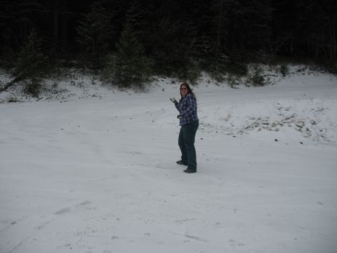 1995 Ford Bronco - A woman stands in a snowy landscape, holding something in her hand. The background features dark trees.