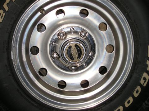 1996 Ford Bronco - A close-up shot focuses on the wheel hub, revealing a Warn manual locking mechanism.