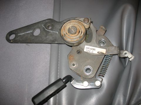 1995 Ford Bronco - Close-up of a vehicle seat adjustment mechanism, showing its internal components and a black lever.