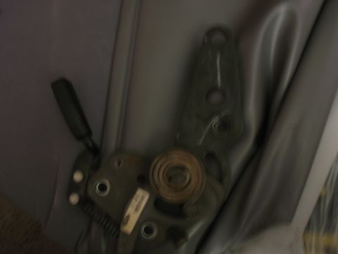 1995 Ford Bronco - Close-up of a vehicle's seat adjustment mechanism, showing internal components and gray upholstery.