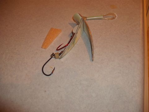 1990 Ford Bronco - A fishing lure with a hook and a piece of foam is laid out on a textured surface.