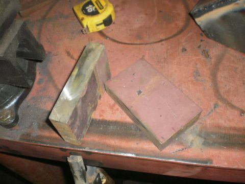 1995 Ford Bronco - Metal blocks and a tape measure are on a workbench, suggesting automotive parts or repair work.