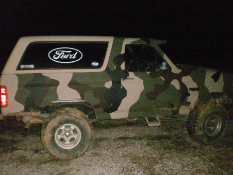1995 Ford Bronco - This Ford Bronco is covered in a camouflage wrap, obscuring its original paint and making year identification difficult.