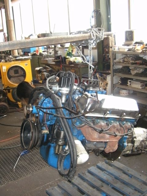 1972 Ford Ranchero - V8 engine with chrome valve covers and distributor, being worked on in a cluttered workshop environment.